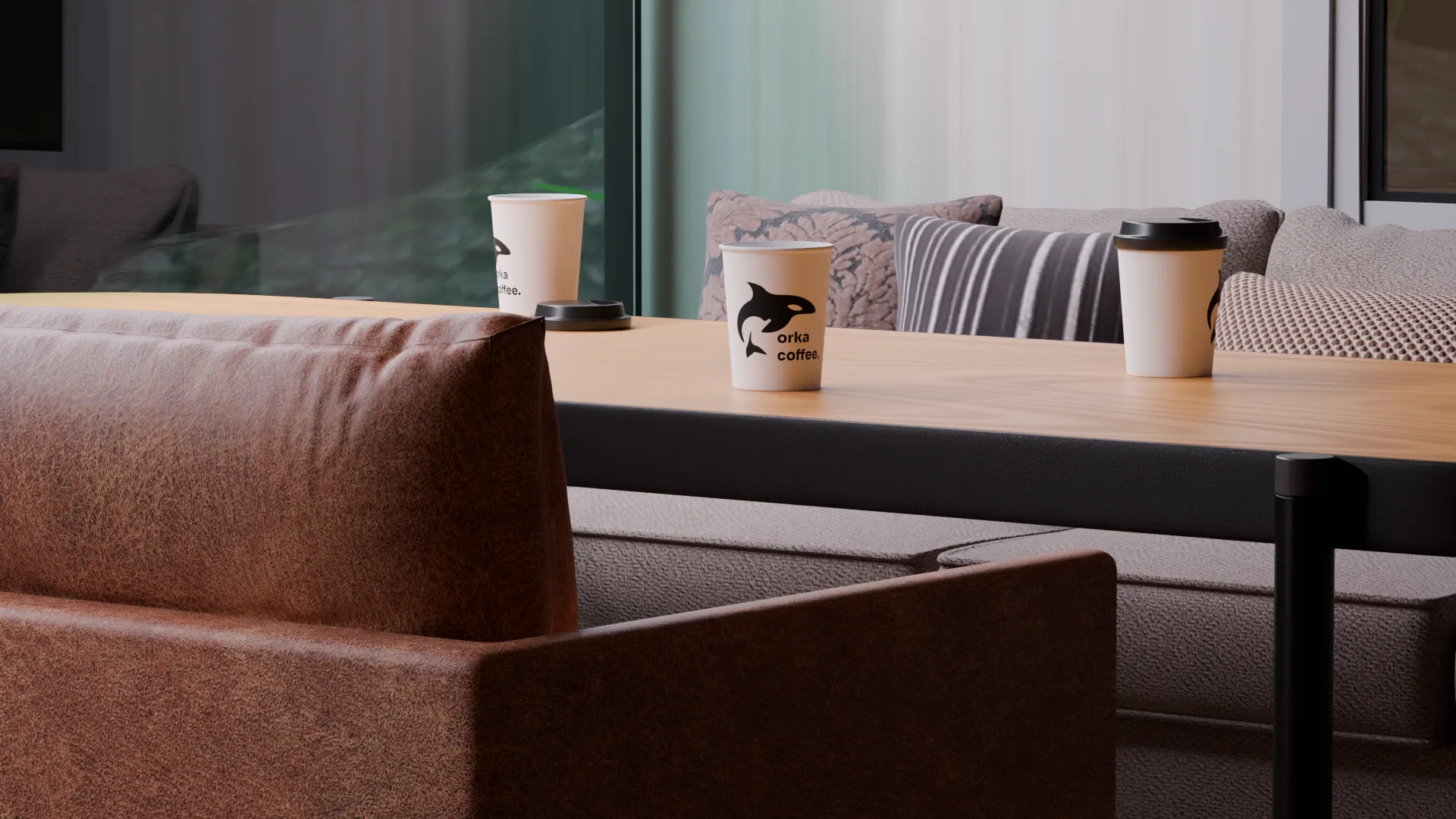 The cafe interior, branded cups on a table beside a leather sofa